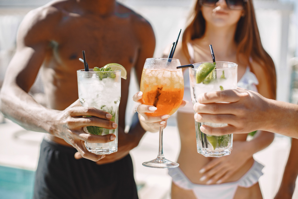 friends-relaxing-sunbeds-near-swimming-pool почивка-приятели-релакс-напитки